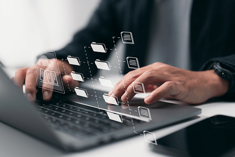 Businessman types on a gray laptop computer to set up AP processes.