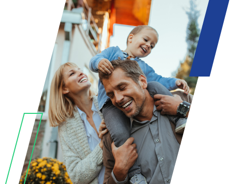 Family spending time together outdoors, with a child riding on an adult's shoulders.